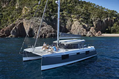 Nautitech 40 Open sailing catamaran at anchor off a rocky coast