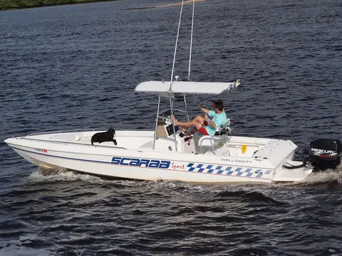 Wellcraft Scarab Sport center console running with a dog aboard, shown for reference
