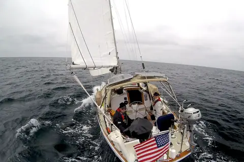 Alberg 37 sailing under main and jib, seen from aloft looking down into the cockpit