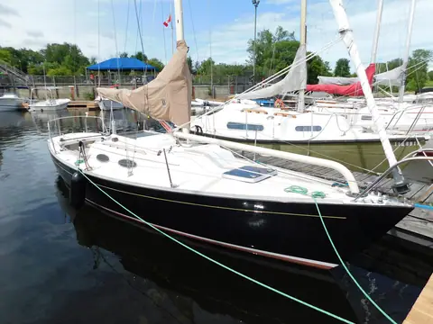 Dark-hulled Alerion Express 28 tied up in a marina