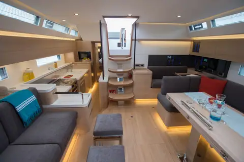 Amel 50 saloon with light oak joinery, dinette, galley and companionway steps
