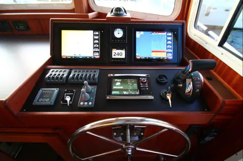 American Tug 365 pilothouse helm with stainless wheel, twin displays and teak dash