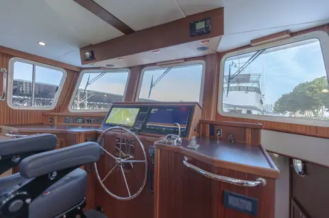 American Tug 435 pilothouse helm with wheel, twin displays and teak joinery