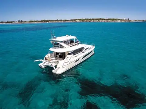 Aquila 44 seen from the air at anchor over turquoise water and dark weed beds