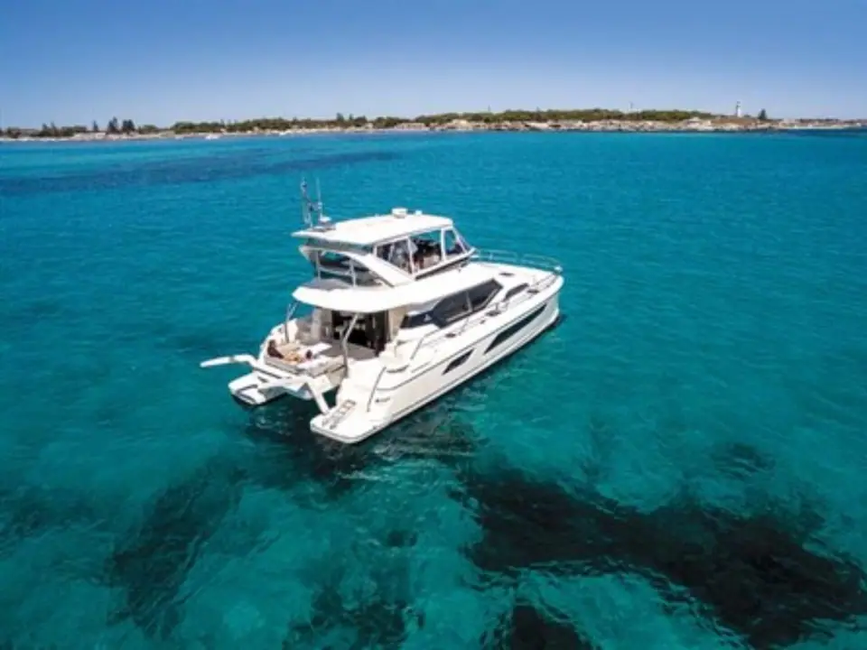 Aquila 44 seen from the air at anchor over turquoise water and dark weed beds