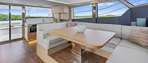 Aquila 50 Yacht main salon with U shaped dinette, galley aft and wide side windows