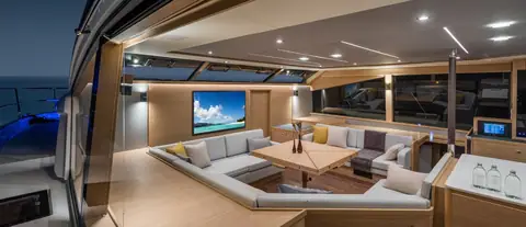 Aquila 54 Yacht main salon with wraparound seating, coffee table and TV under wide windows