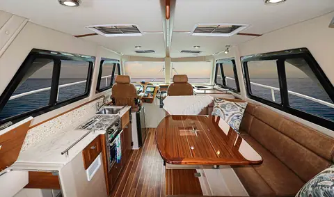 Aspen C108 cabin with galley to port, teak dinette table and settee to starboard