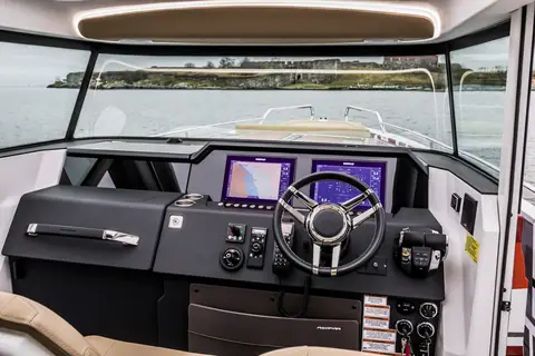 Axopar 37 XC Cross Cabin helm with twin displays, wheel and the windshield ahead