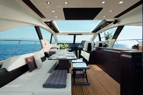 Azimut 55S main salon with dark wood, white sofa, dining table and glass roof panels