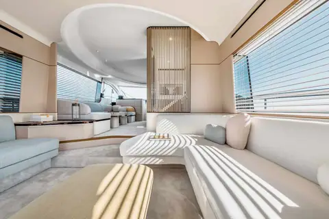 Azimut 68 main salon with curved white sofas and slatted wood divider