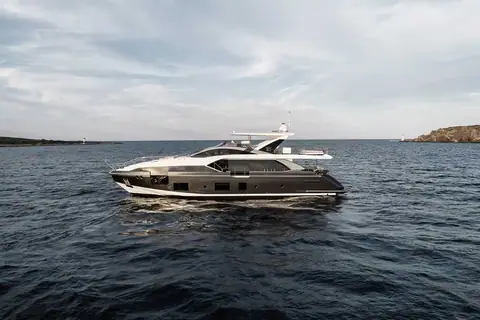 Azimut Grande 27 Metri cruising toward the camera with a headland behind