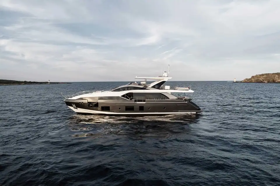 Azimut Grande 27 Metri cruising toward the camera with a headland behind