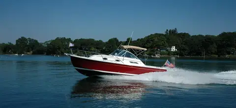 Back Cove 26 with a red hull running fast across a calm harbor