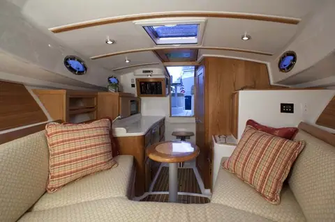 Back Cove 30 cabin with V berth settee, cherry joinery and a small table