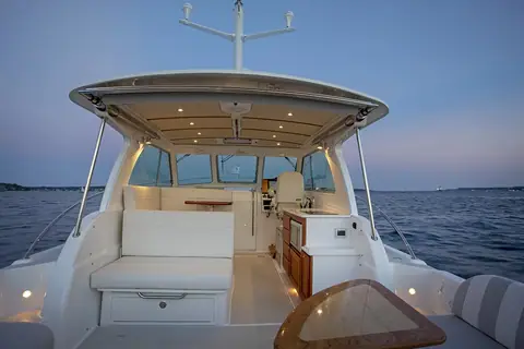 Back Cove 34O cockpit looking forward into the open hardtop saloon at dusk