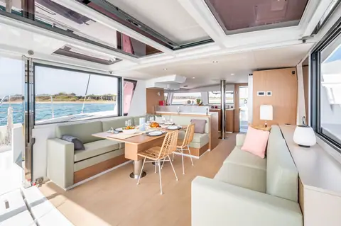 Bali 4.6 saloon seen from aft with dining table, settees and the galley beyond