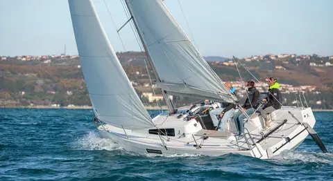 Beneteau First 27 heeled upwind under main and jib with crew on the rail