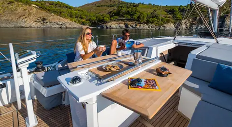Beneteau Oceanis 46.1 cockpit with table and guests at anchor