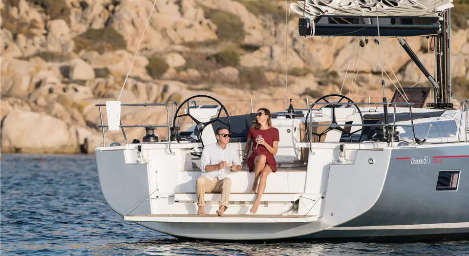 Beneteau Oceanis 51.1 stern with twin wheels and guests on the transom platform