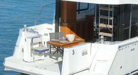 Beneteau Swift Trawler 35 cockpit with table and side deck steps up to the flybridge