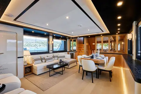 Bering 77 Veronika main saloon with sofas and dining table aft of the galley