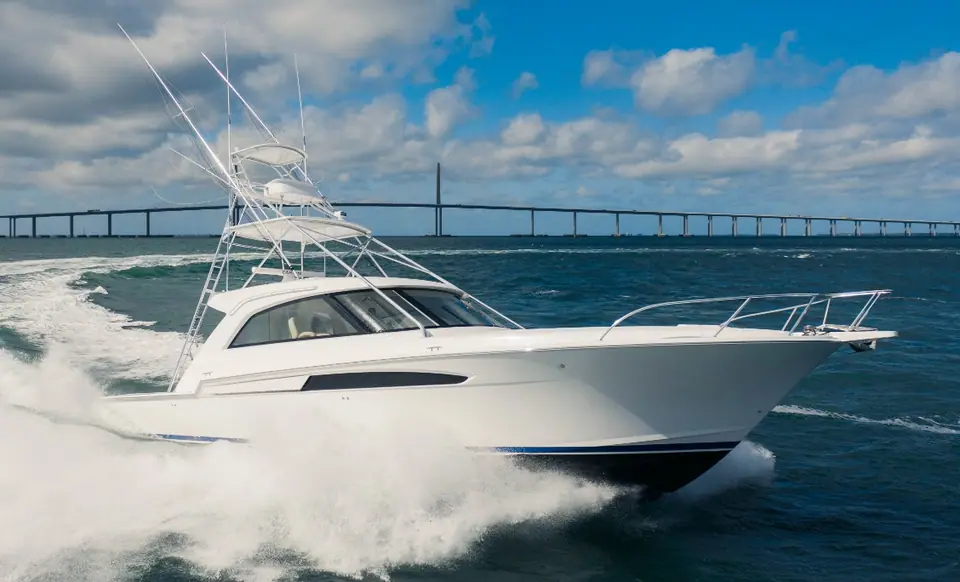 Bertram 50S with a tuna tower running fast near a bridge