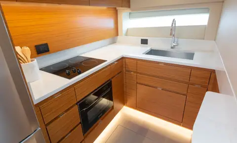 Galley of the Bertram 50S with teak cabinets and a cooktop