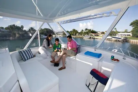 Flybridge of the Bertram 54 Convertible with guests seated forward of the helm