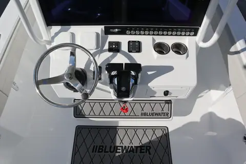 Helm console of the Bluewater 25T with a stainless wheel and Suzuki controls