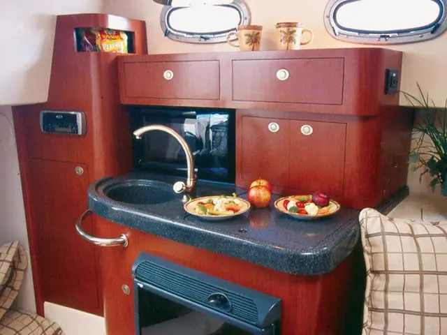 Galley of the Boston Whaler 305 Conquest with cherry cabinets and a sink