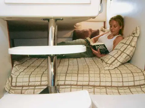 Cabin berth of the Boston Whaler 305 Conquest with a woman reading