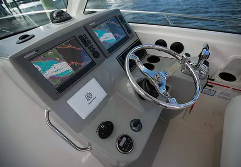 Helm of the Boston Whaler 315 Conquest with twin displays and a stainless wheel