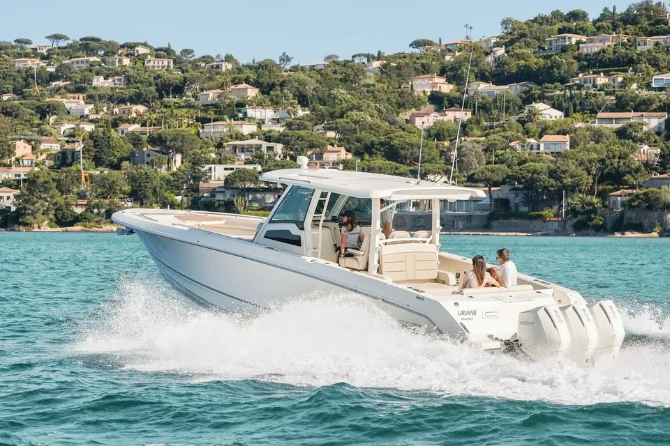 Boston Whaler 380 Outrage cruising past a hillside coastline