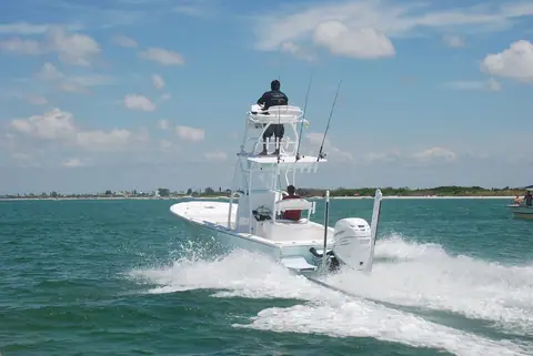 Canyon Bay 24H hybrid bay boat running with an angler on its fishing tower