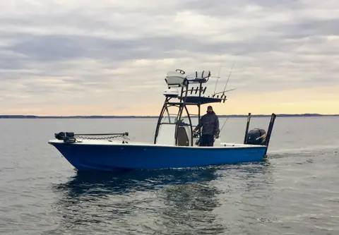 Canyon Bay 24H with a blue hull and fishing tower idling at dusk