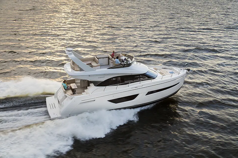Carver C52 Command Bridge running at speed with its flybridge and wide hull windows