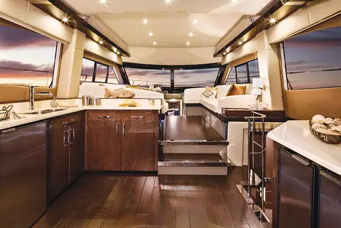Carver C52 Command Bridge main salon with galley, dark wood floor and wide windows