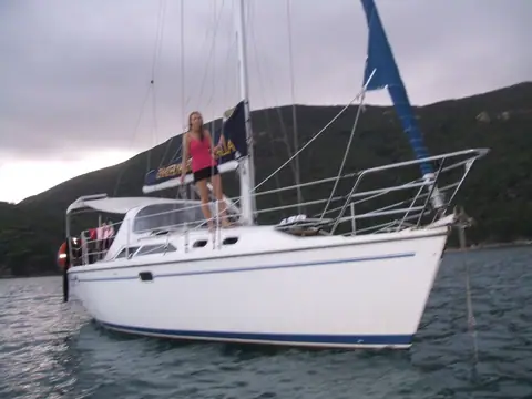 Catalina 320 charter yacht at anchor in a hilly bay