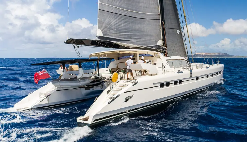 Catana 90 Orion under main and jib with crew on its wide aft deck