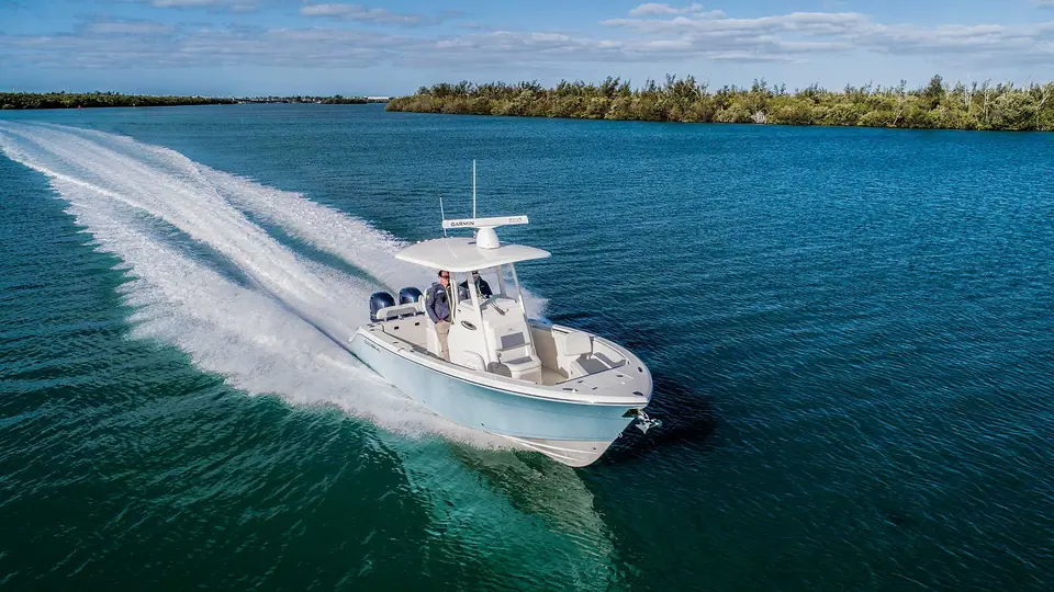 Aerial view of a Cobia 240 CC carving a turn with its T top and light blue hull
