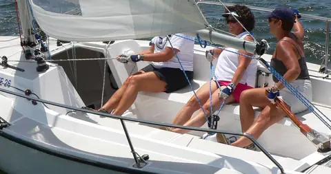 Crew hiking out in the open cockpit of a Colgate 26 under sail