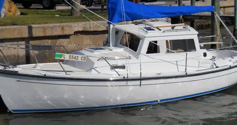 Com-Pac 23 Pilothouse tied up at a dock showing its hull and pilothouse profile