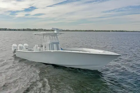 Conch 33 center console underway with triple outboards and a gray hull