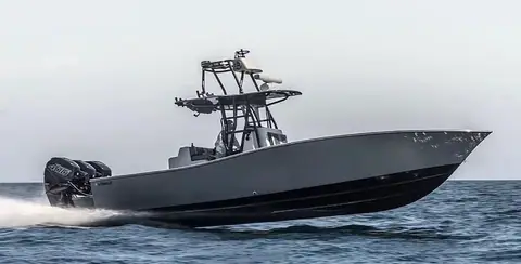 Conch 33 running fast with a gray hull, tower and triple outboards