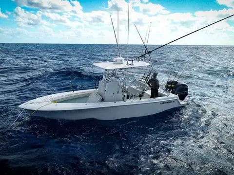 Contender 25T drifting offshore with an angler at the transom and rods in the T top