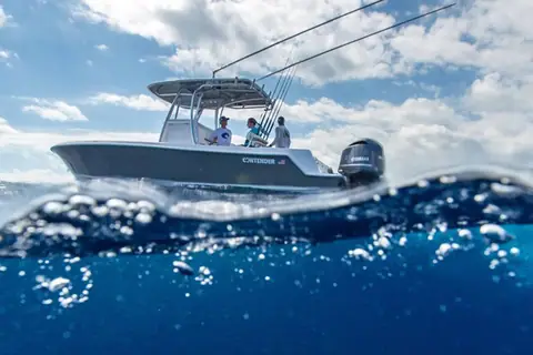 Contender 28T idling offshore with people aboard and rods in the T top