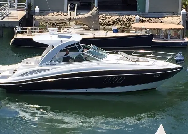 Cruisers Yachts 350 Express idling past waterfront docks in profile