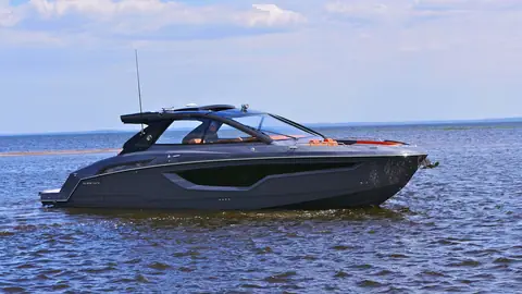 Cruisers Yachts 42 GLS with a dark hull and hardtop idling on open water