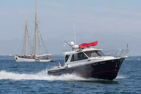 Cutwater C28 running at speed with a schooner sailing behind